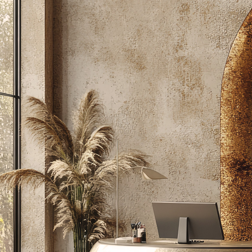 Modern workspace featuring a textured beige wall, a monitor on a sleek desk, and a large decorative pampas grass arrangement.